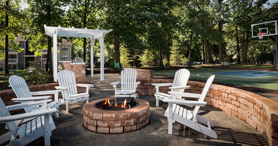 a patio with chairs and a fire pit and a basketball court