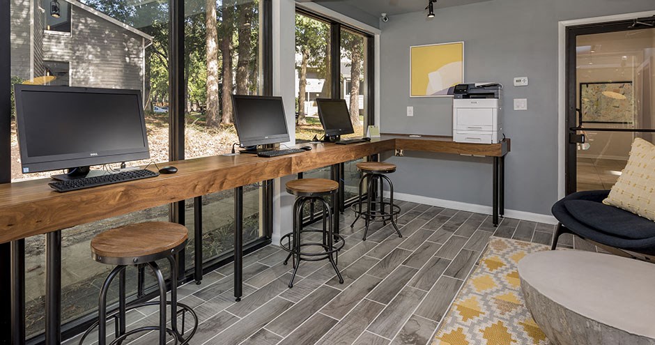 a home office with two computers on a wooden desk