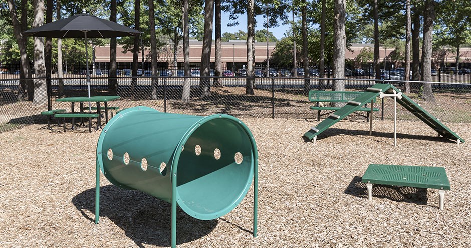 a green seesaw in a playground at a park
