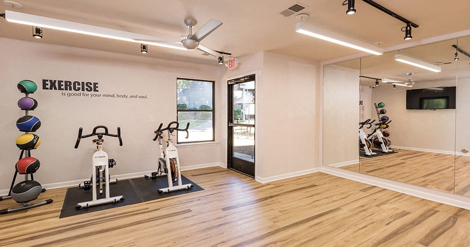 a gym with exercise equipment and a glass door