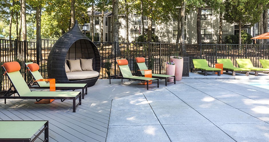 a lounge area with chairs and tables on a patio