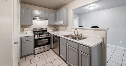 A kitchen with a stove top oven and a sink.