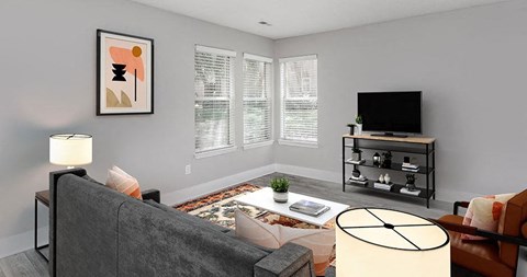 A living room with a grey couch, a white table, and a television on a stand.