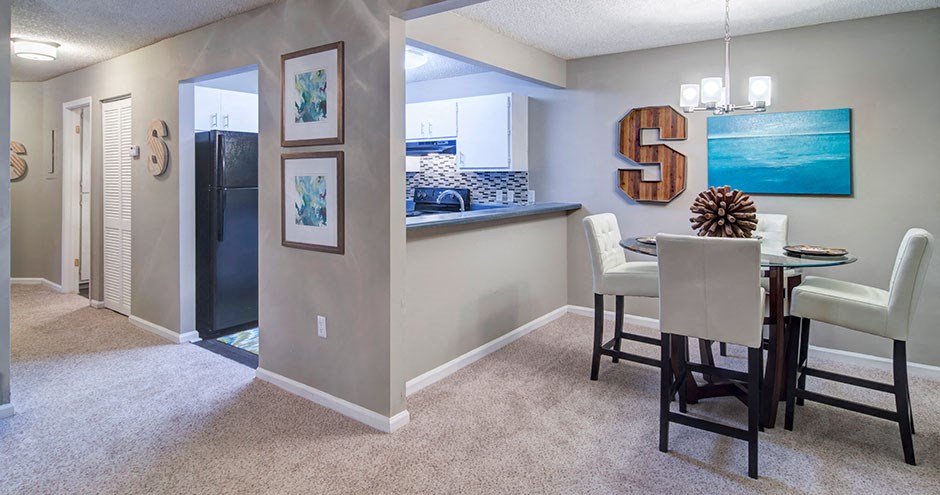 a dining room and kitchen with a table and chairs