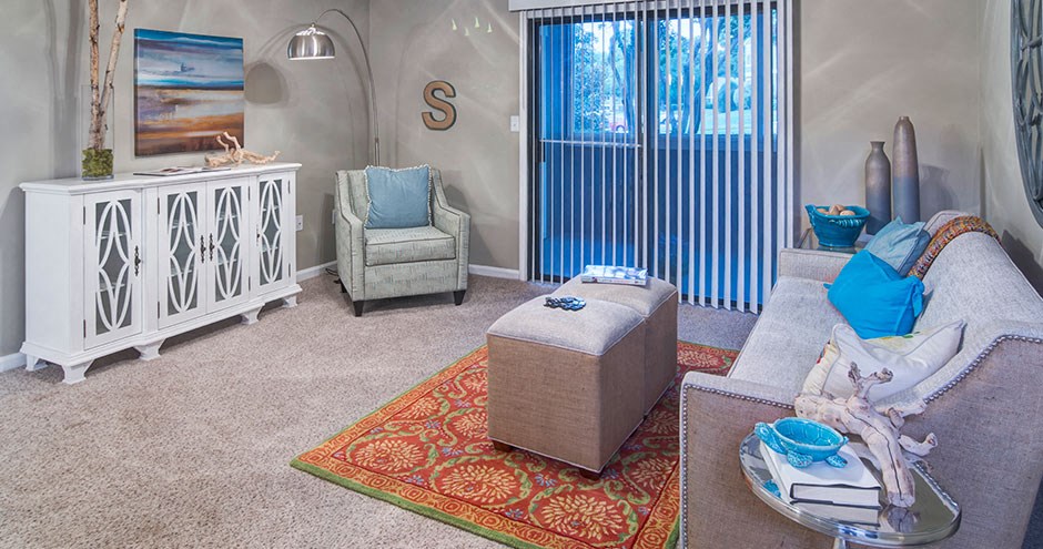 a living room with a couch and chairs and a window