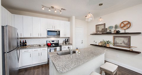 a kitchen with white cabinets and a granite counter top