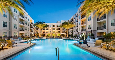 a swimming pool at an apartment complex with palm trees