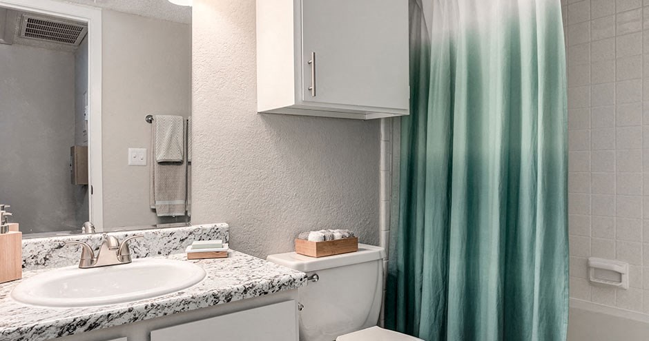 a bathroom with a white sink and a green shower curtain