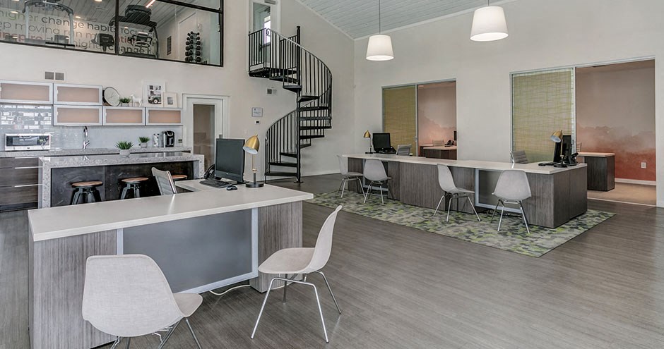 an office with a desk and chairs and a staircase