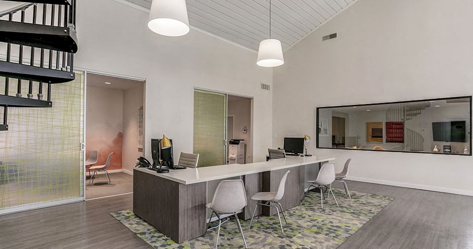 a conference room with a desk and chairs and a mirror