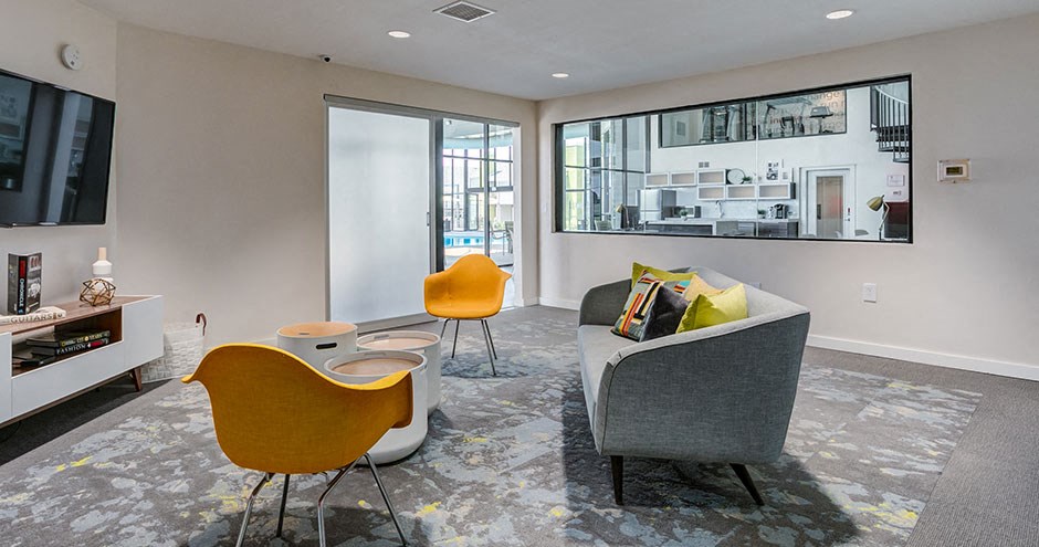 a living room with a couch and chairs and a television