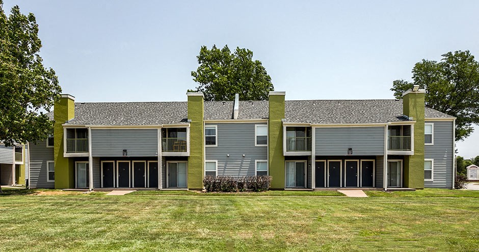 a gray and green house with a grass yard