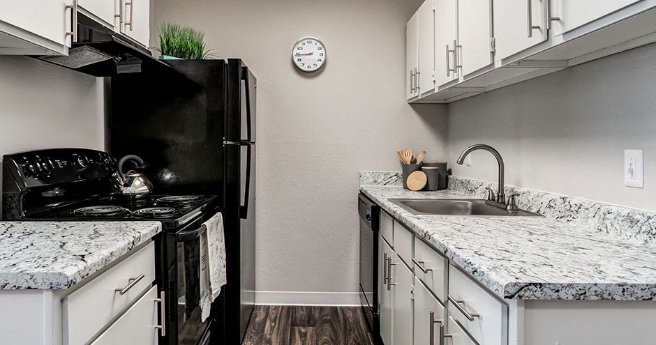 a kitchen with granite counter tops and a black refrigerator