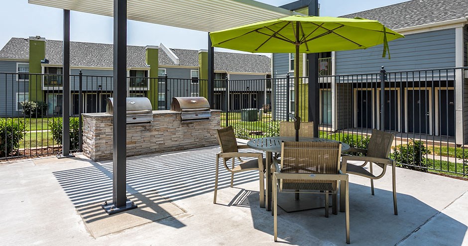 a patio with a table and chairs under an umbrella