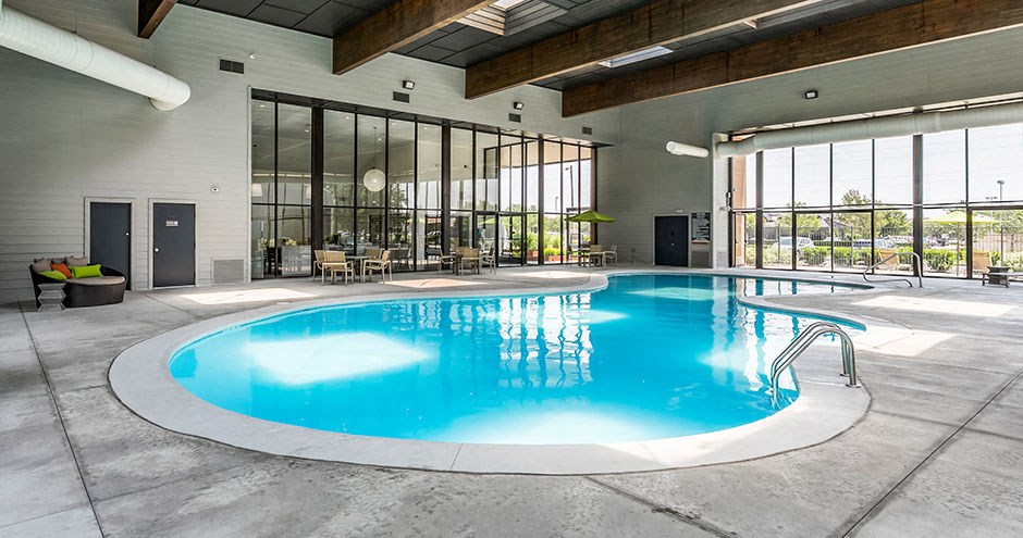 a swimming pool in the middle of a building with glass walls