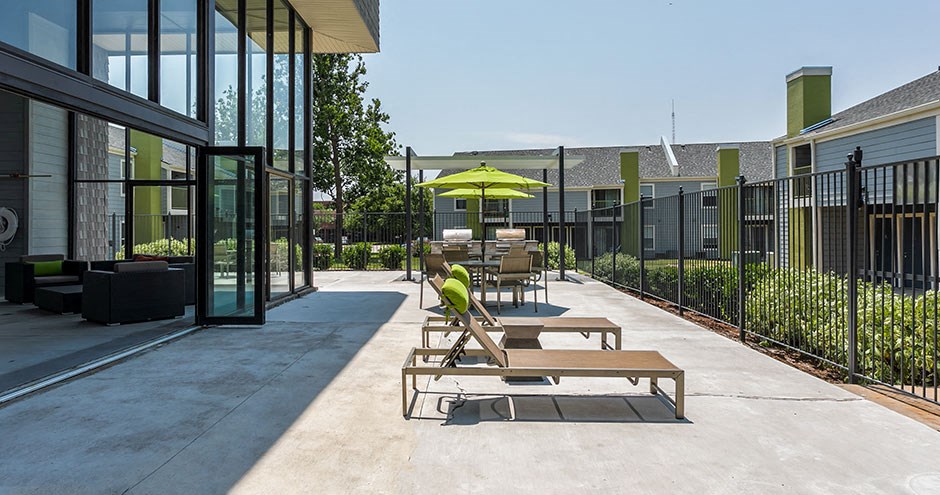 a patio with tables and umbrellas outside of a building