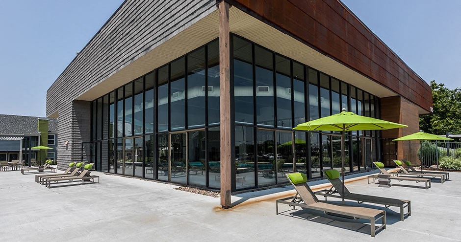 a patio with chairs and umbrellas outside of a building
