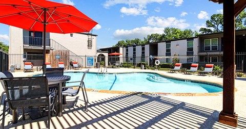a swimming pool with chairs and an umbrella