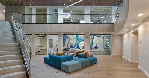 a living room with a blue couch and a staircase
