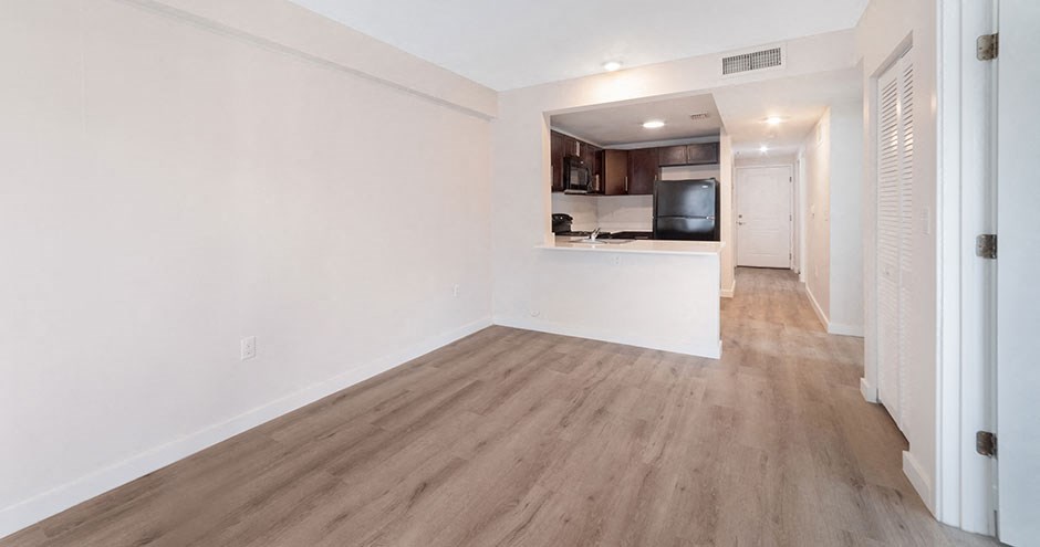 an empty living room with white walls and wood floors