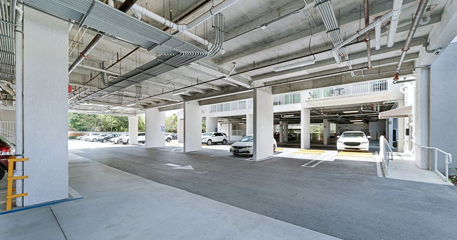 the parking garage of a building with cars in it