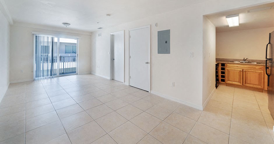 the living room and kitchen of an empty apartment