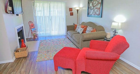 a living room with a couch and two red chairs
