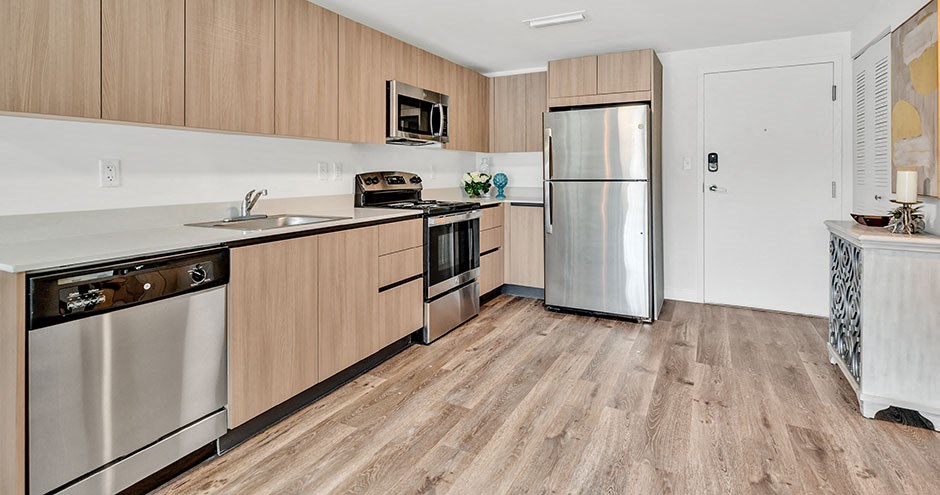 a kitchen with wooden floors and stainless steel appliances