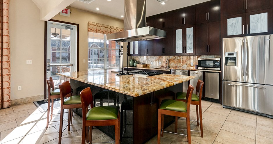 a large kitchen with a marble counter top and stainless steel appliances