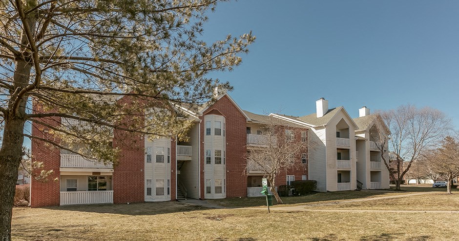an apartment building with a yard in front of it