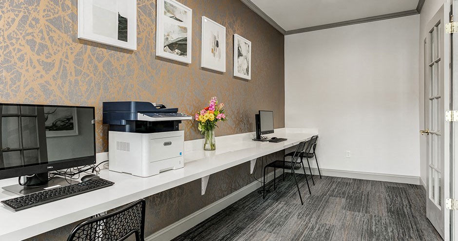 a office with a computer and a printer on a desk