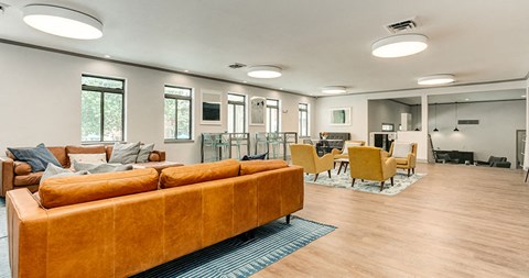 a living room with a couch and chairs and a dining room table