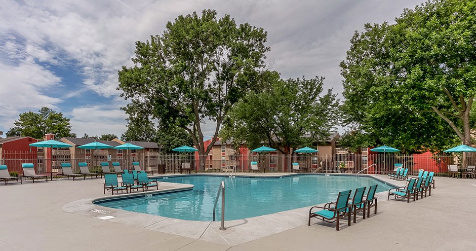 a resort style pool with chairs and umbrellas