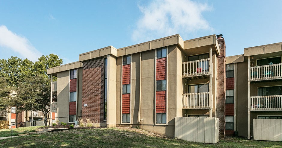 a brick apartment building with red shutters