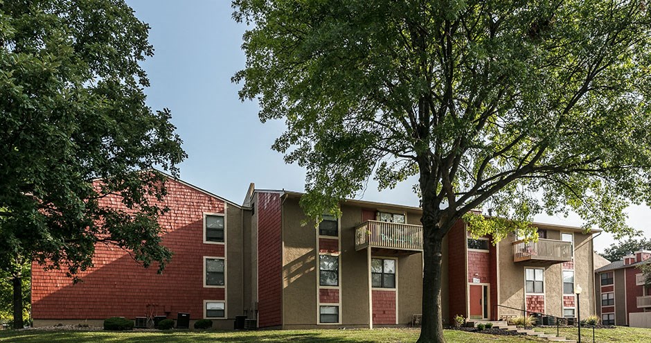 a row of brick apartment buildings with trees