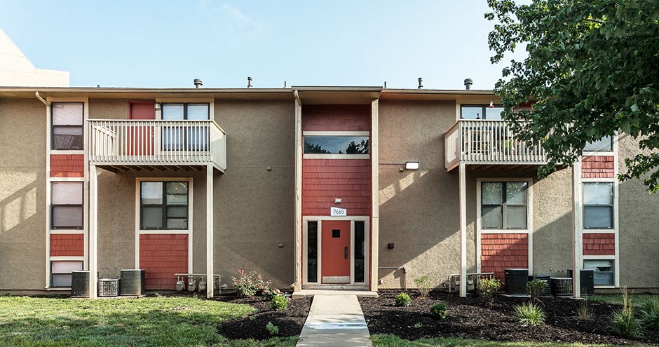 a brick apartment building with a red door