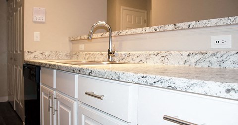 a kitchen with white cabinets and a sink
