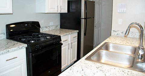 a kitchen with a stove sink and refrigerator
