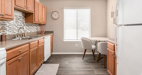 a kitchen with wooden cabinets and a table with chairs