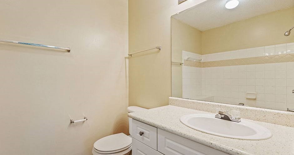 a bathroom with a sink toilet and a mirror