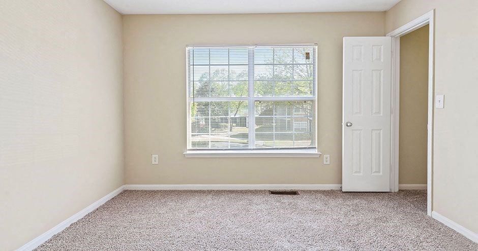 an empty room with a window and a door