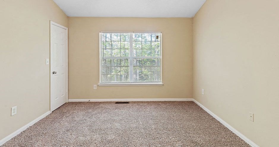 an empty room with a window and a door