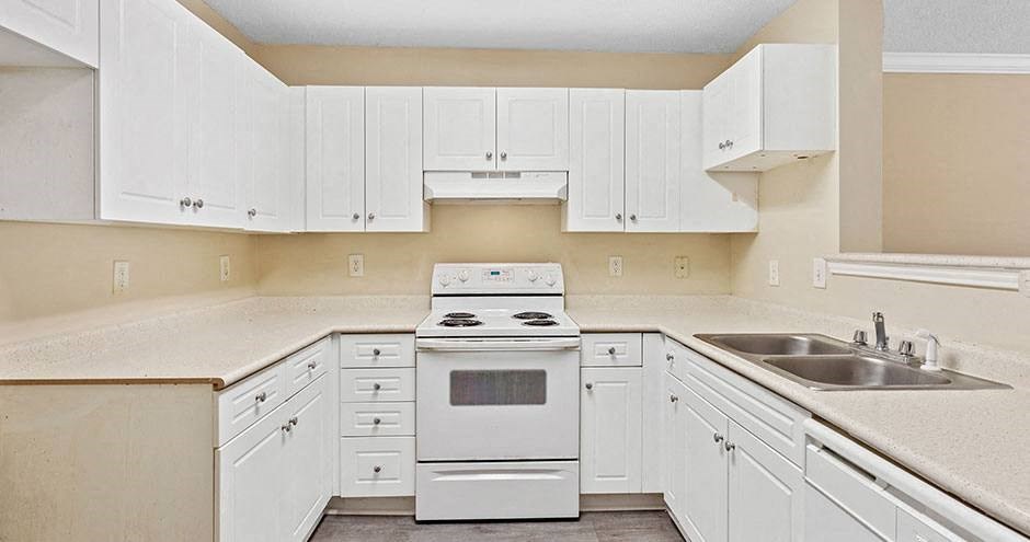 a kitchen with white cabinets and a stove and a sink
