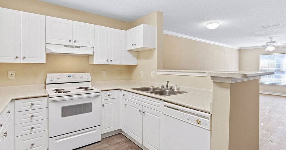 a kitchen with white cabinets and a stove and a sink