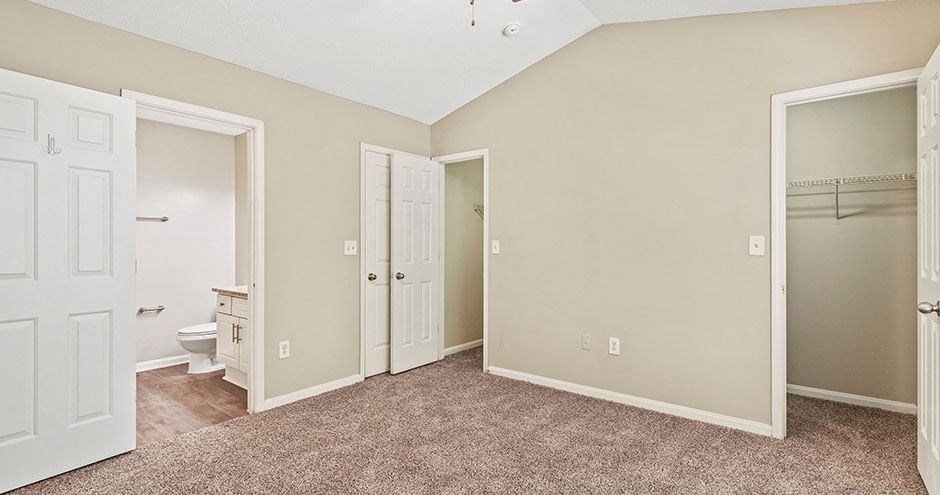an empty room with a bathroom and a closet