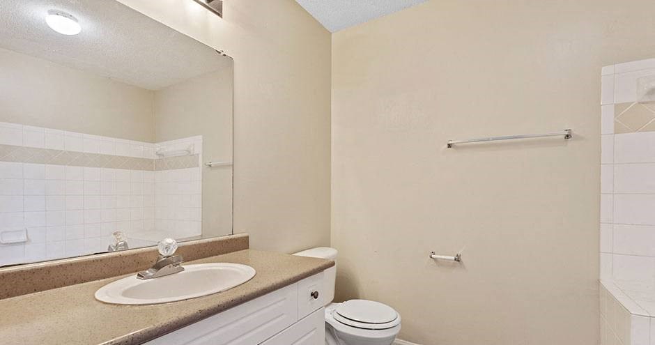 a bathroom with a sink toilet and a mirror