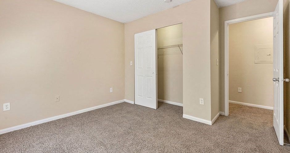 an empty room with a closet and an open door