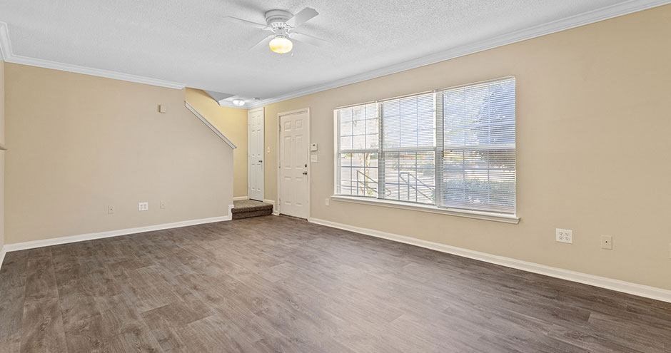 an empty room with a ceiling fan and a window