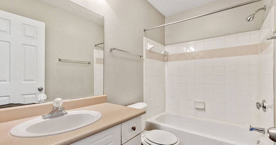 a bathroom with a sink and a tub and a mirror