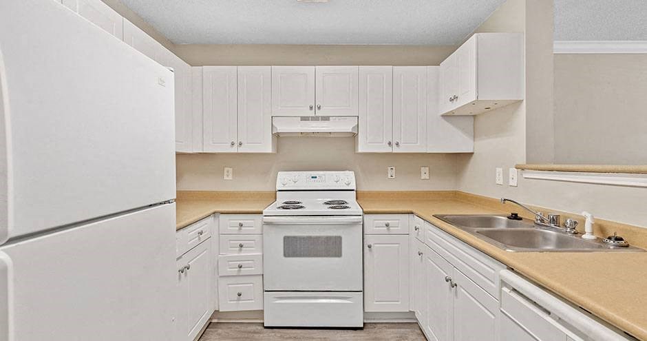 a white kitchen with a stove and a sink